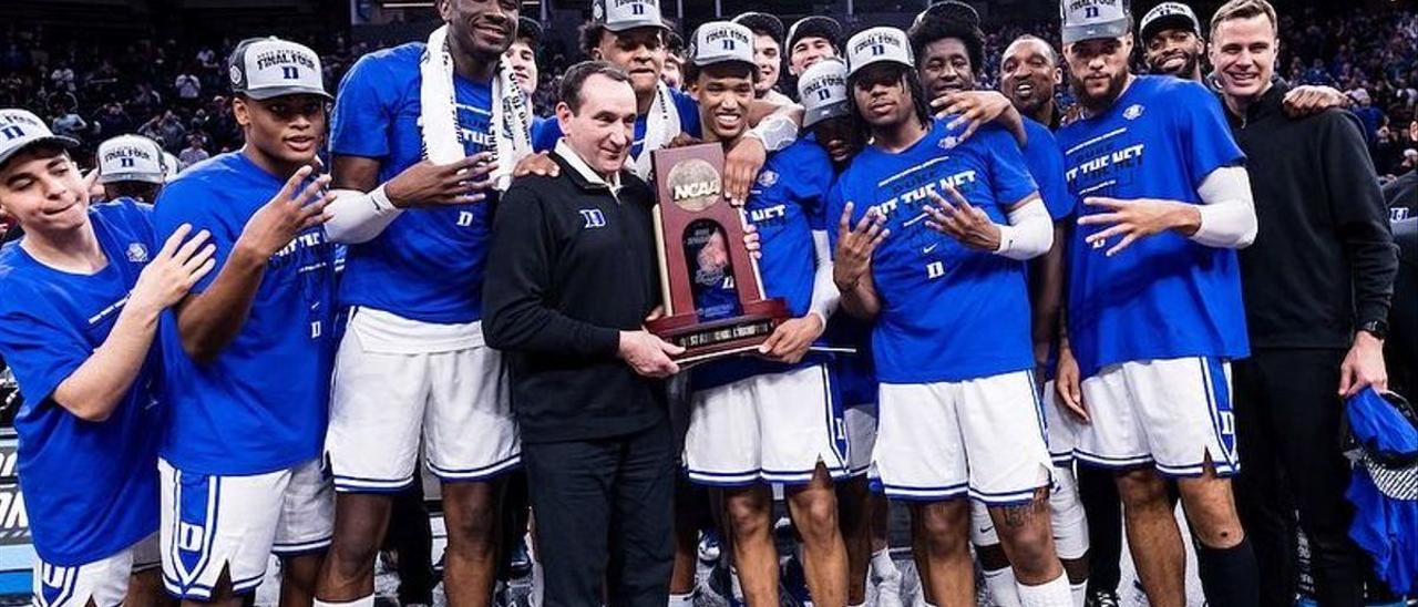 Mike Krzyzewski posa al frente del equipo de Duke con el trofeo de campeón regional.