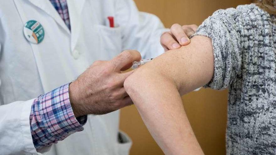 Un facultativo vacuna a una mujer, en un centro de salud de Vigo. // Paula Fariña