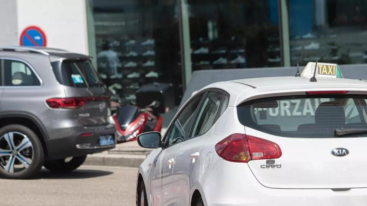 Un taxi y un Uber, en el aeropuerto de Peinador.