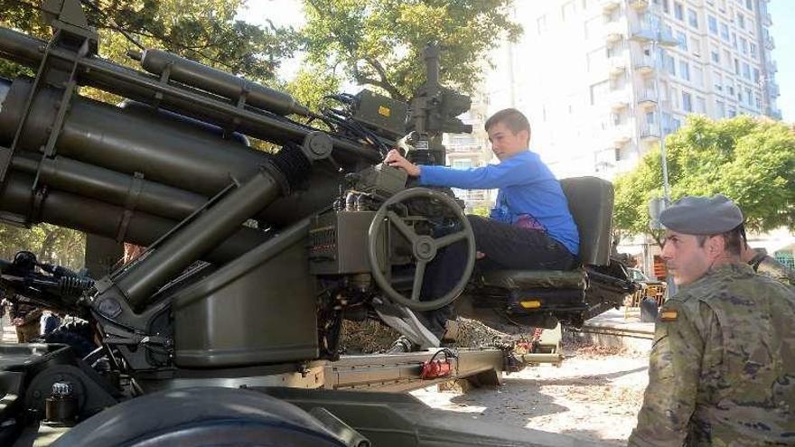 Un soldado explica a un niño el funcionamiento de un obús. // R.V