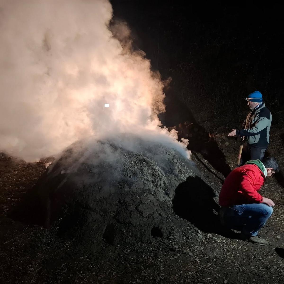 La carbonera ja en funcioinament cremant la llenya amb Saulo Pujolàs