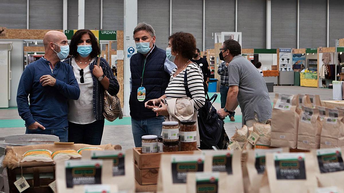 Varias personas, tras uno de los stands de la feria. |