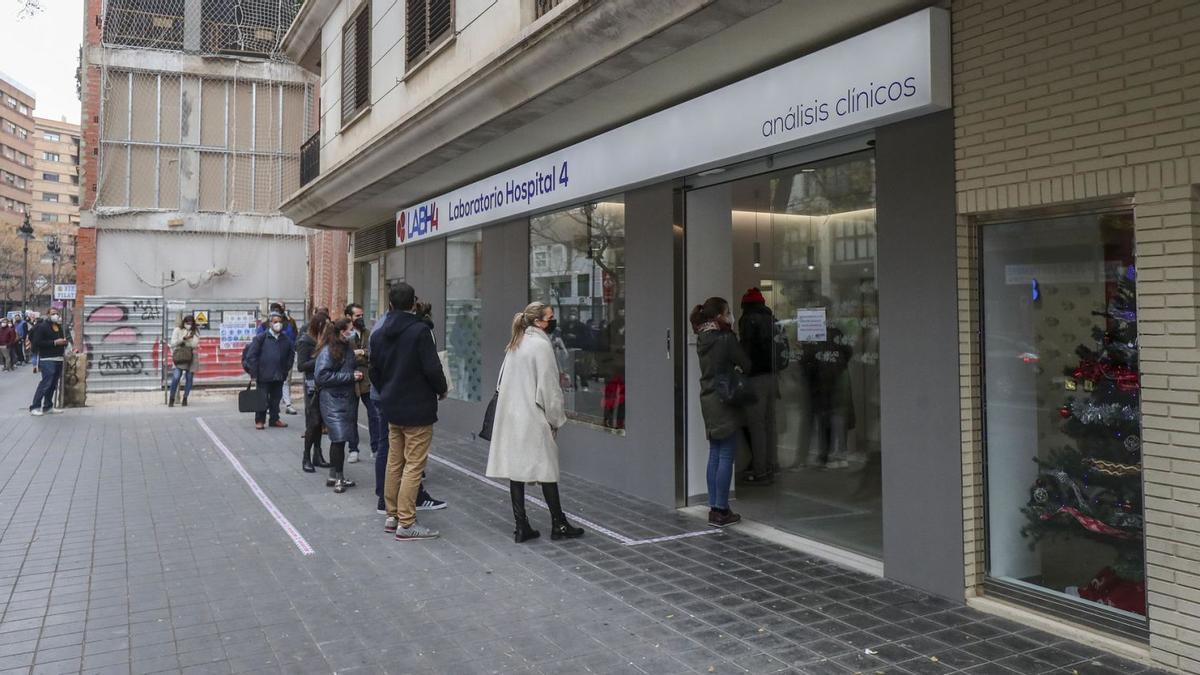 Colas a las puertas de un laboratorio privado para hacerse pruebas PCR antes de la Nochebuena. | FRANCISCO CALABUIG