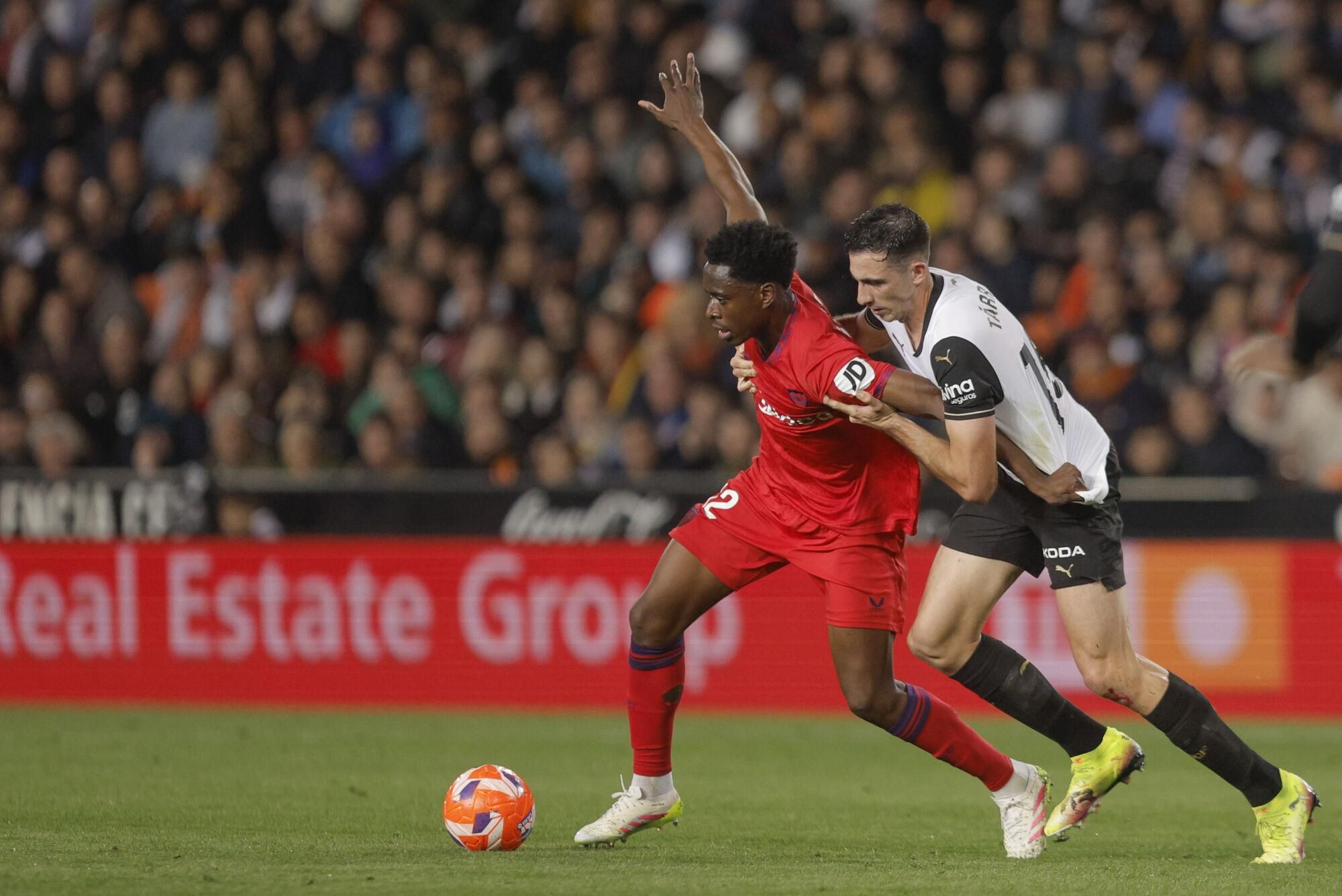 VALENCIA, 11/04/2025.- El defensa del Valencia César Tárrega (d) disputa el balón con el centrocampista belga del Sevilla Albert Sambi durante el partido de Liga disputado este viernes en el estadio de Mestalla. EFE/Kai Forsterling