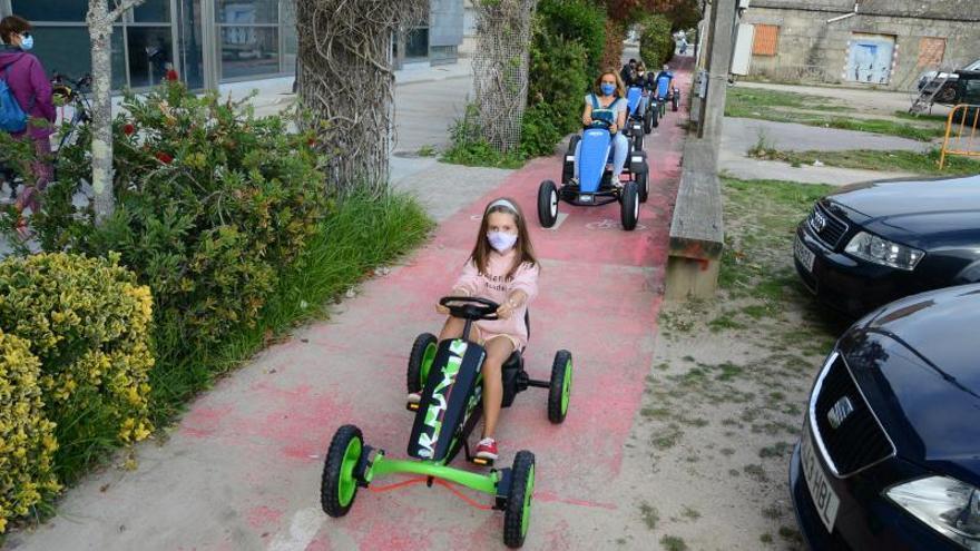 Niñas y adultos disfrutando de los karts en el centro urbano de Cangas. |   // G.NÚÑEZ