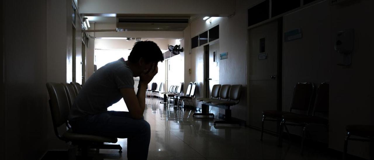 Un joven espera en una sala de espera de un centro de salud.
