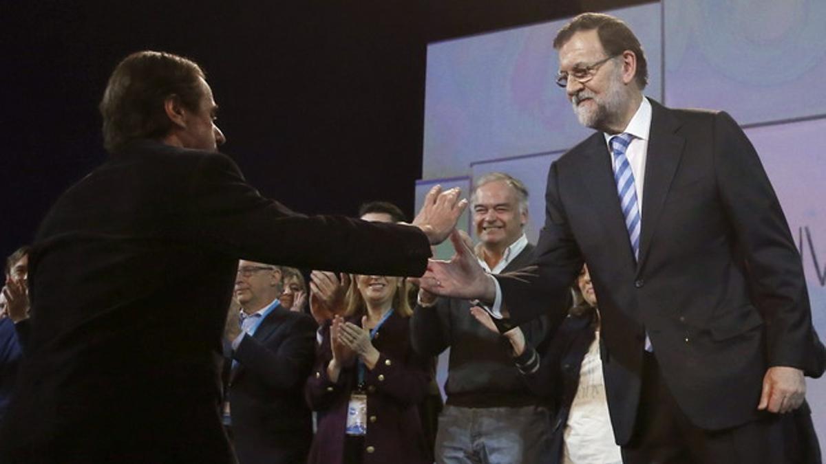 El presidente del Gobierno, Mariano Rajoy, saluda a José María Aznar al finalizar el acto de clausura de la convención nacional del PP