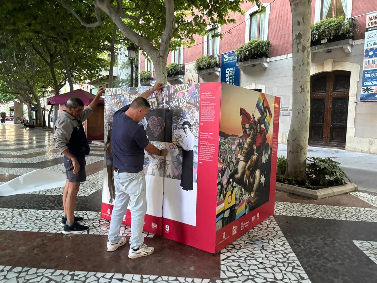 Dos operarios colocan los paneles ya sin pintadas en la exposición