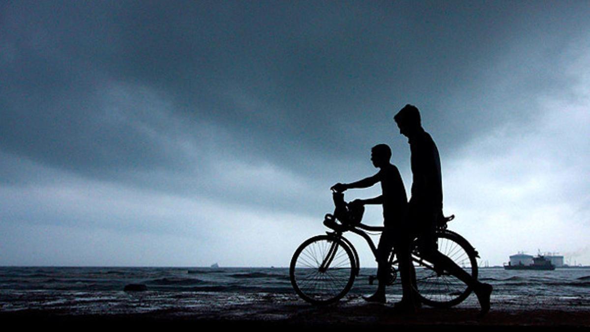 Una parella de joves camina de tornada a casa abans que esclati una tempesta a la ciutat índia de Kochi.