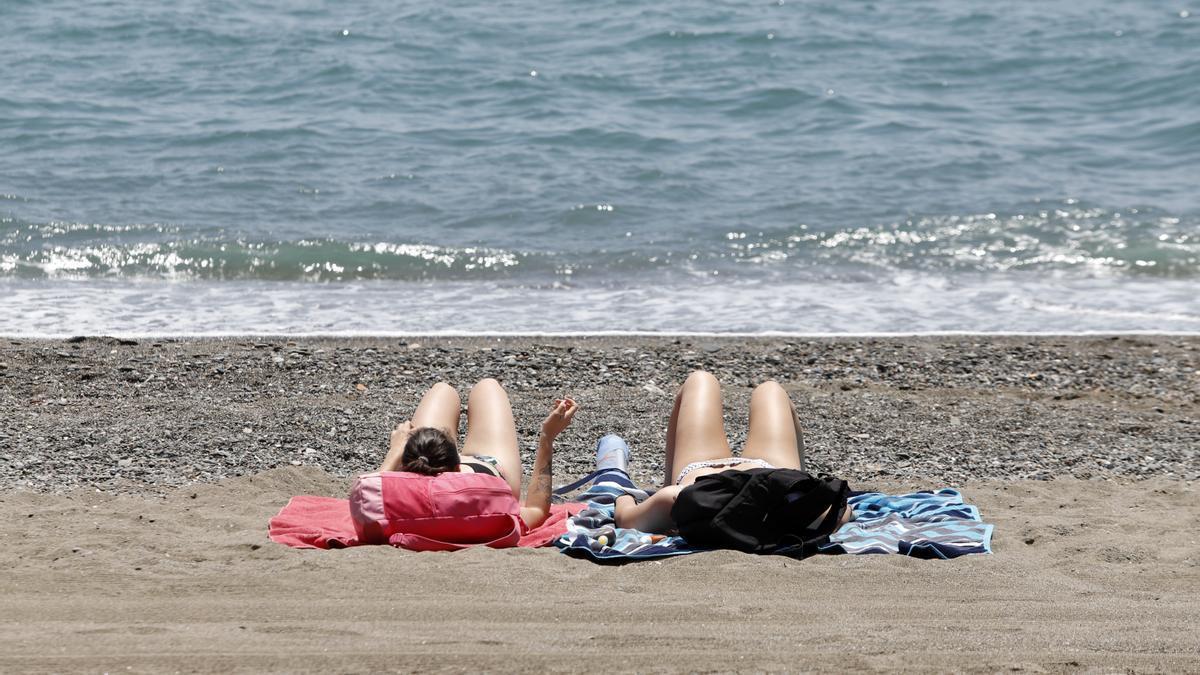 Bañistas en la playa de la Misericordia, barriada de Huelin.