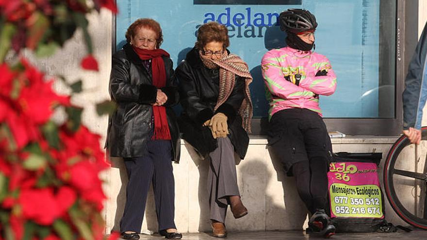 Bufandas. Varias personas muy abrigadas tratan de encontrar algo de calor a la luz del sol ayer al mediodía en Málaga capital.