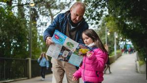 Abuelo y nieta observan el mapa del parque de atracciones Tibidabo