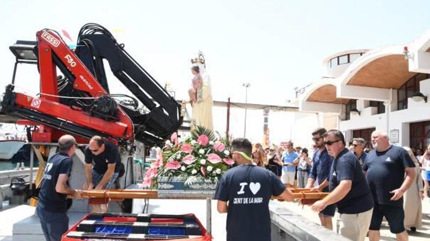 Los pescadores de Xàbia suben a la virgen a la embarcación Chorroll Cinc para la ofrenda en el mar.