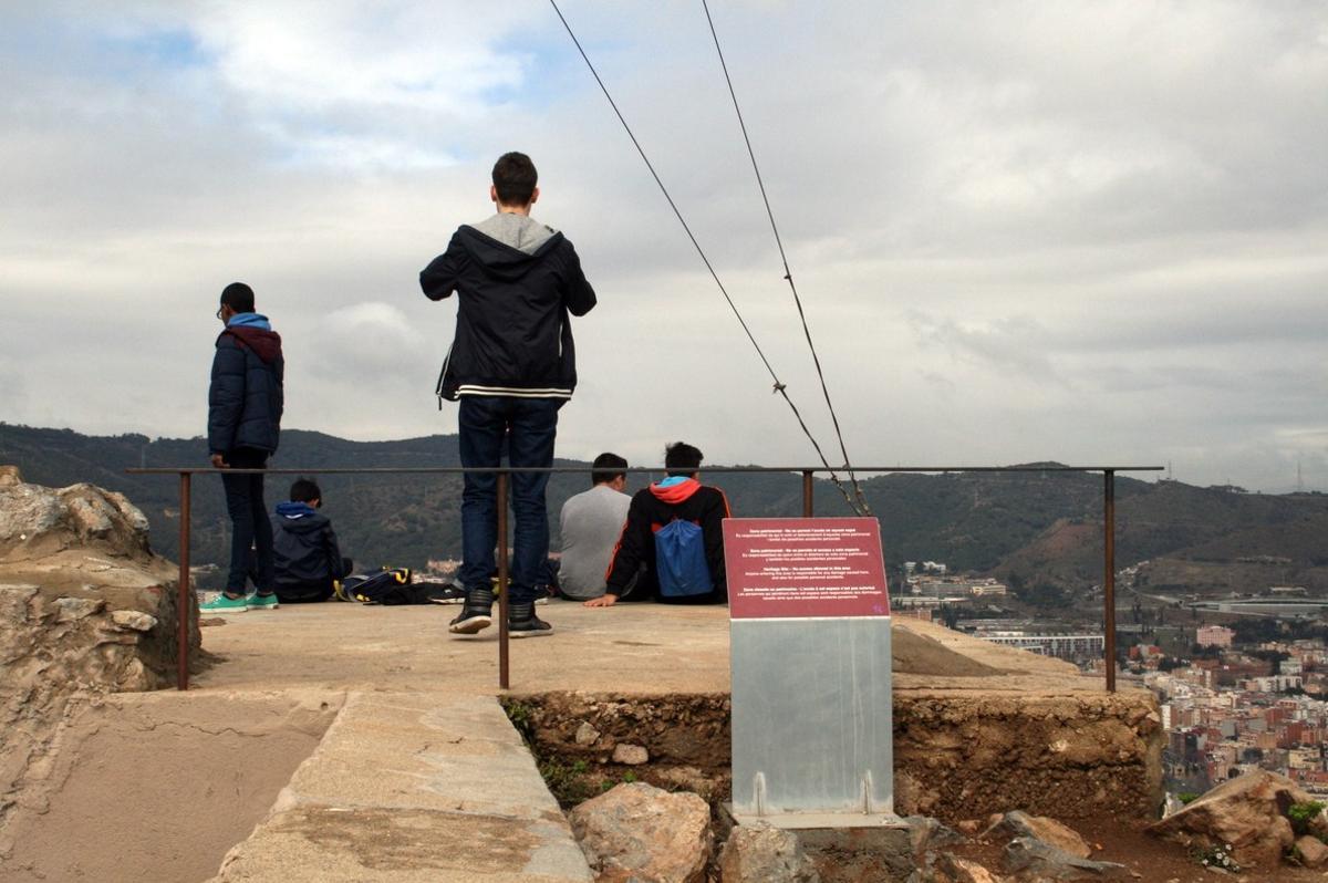 Unos jóvenes contemplan las vistas de Barcelona desde una zona de acceso restringido de la antigua batería del Carmel.