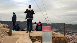 Unos jóvenes contemplan las vistas de Barcelona desde una zona de acceso restringido de la antigua batería del Carmel.