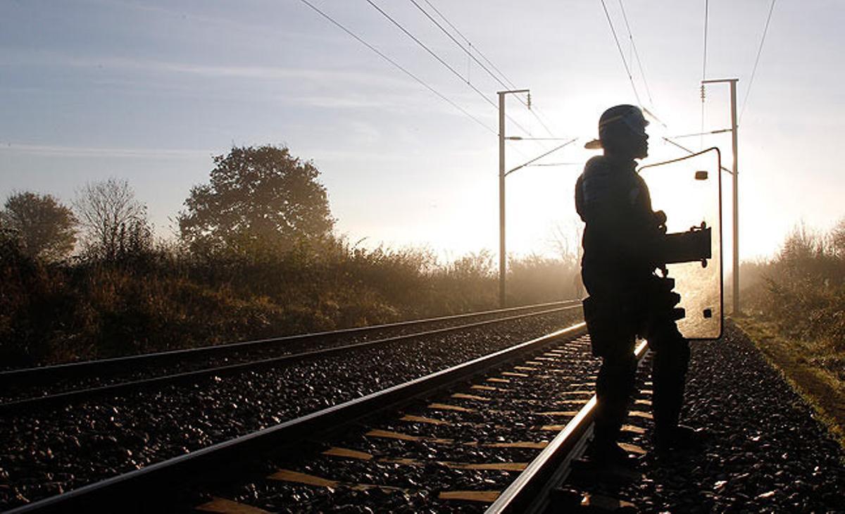 Un soldat vigila la via del tren per on ha de passar un comboi que transporta residus radioactius, a la localitat francesa de Lieusaint.