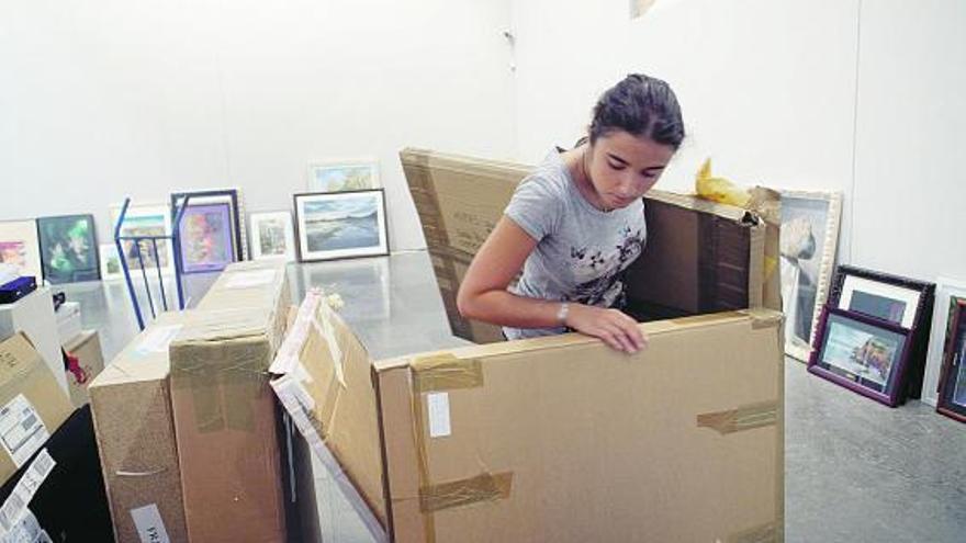 Una joven selecciona los paquetes enviados con obras para la bienal, durante el montaje en la Universidad.