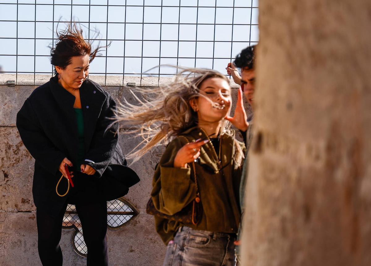 El viento provoca molestias a turistas en el Micalet en València este viernes.