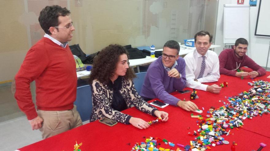 Los participantes en el taller ante las piezas del juego de Lego.