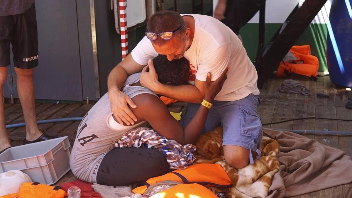 Un miembro de Open Arms consuela a una migrante en el buque.