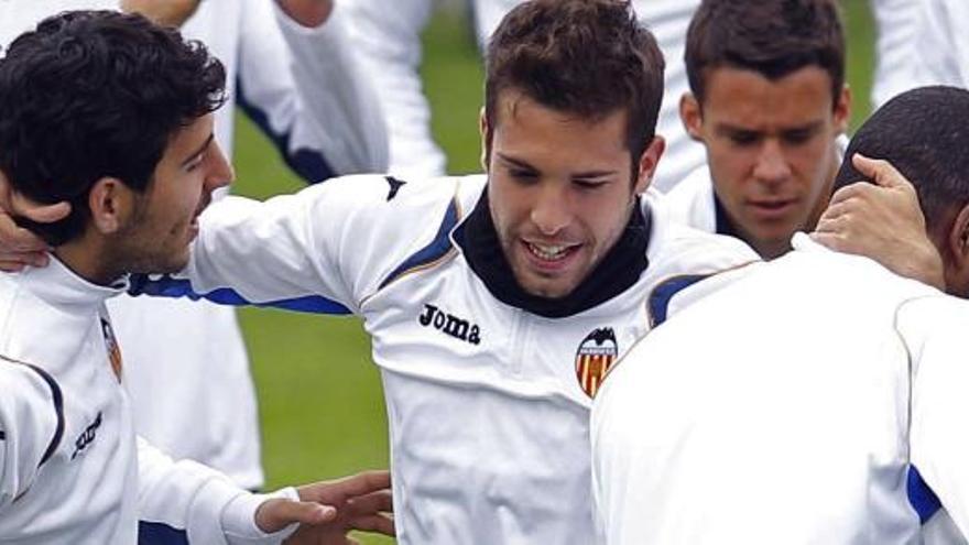 El defensa del Valencia Jordi Alba bromea con sus compañeros durante el entrenamiento de hoy.