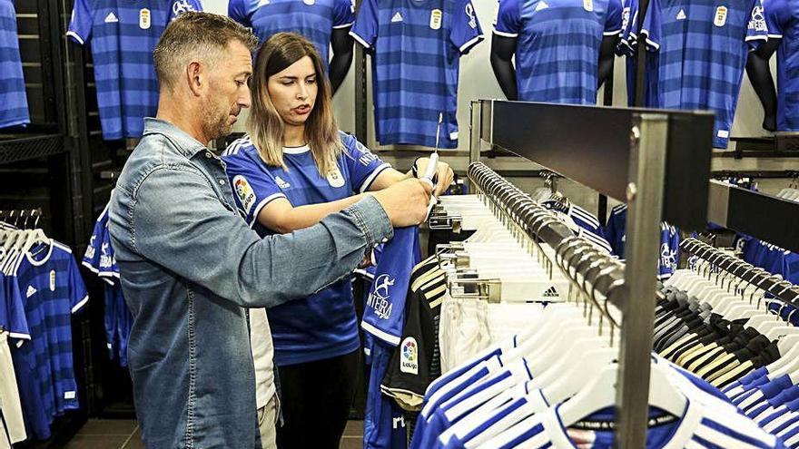 Un cliente mira una camiseta del Oviedo en la tienda del club.