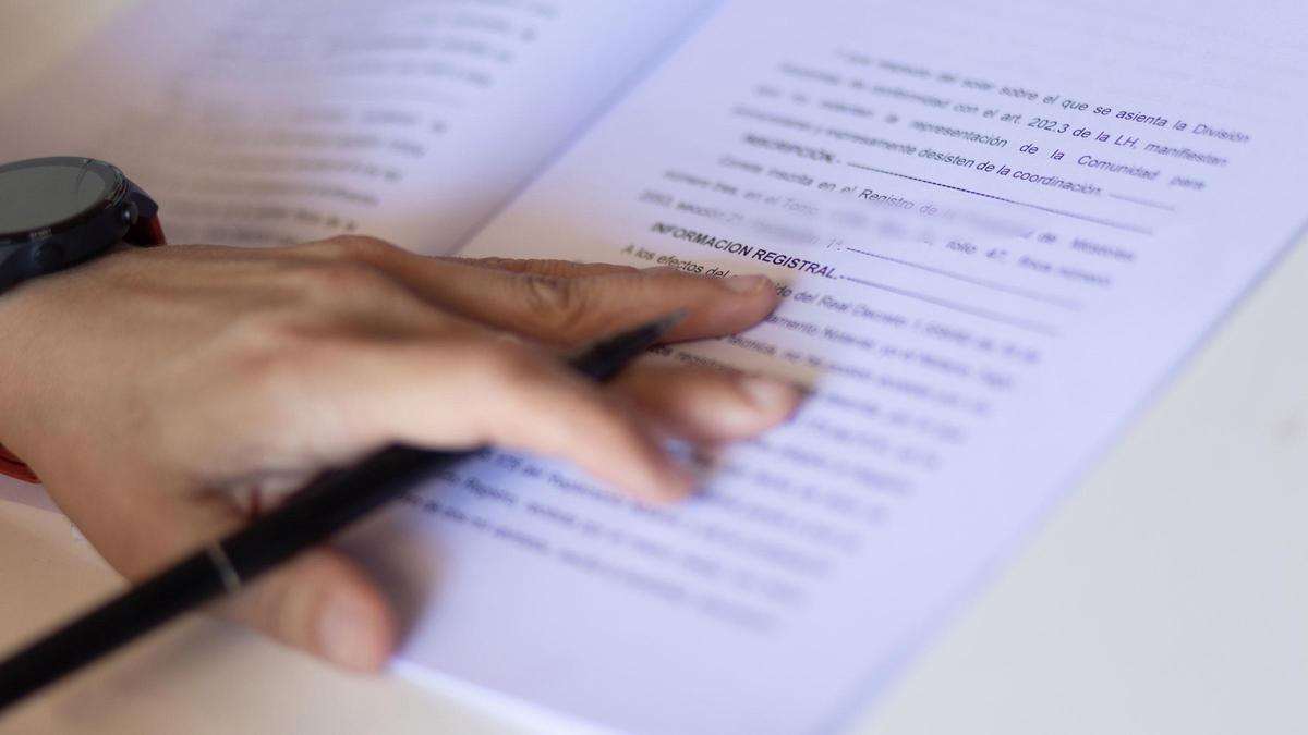 Archivo - Una mujer con un bolígrafo, señala una escritura de compraventa de una hipoteca