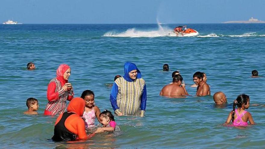 Un grup de dones es banyen totalment cobertes de roba a la platja de Bizerte, a Tunísia