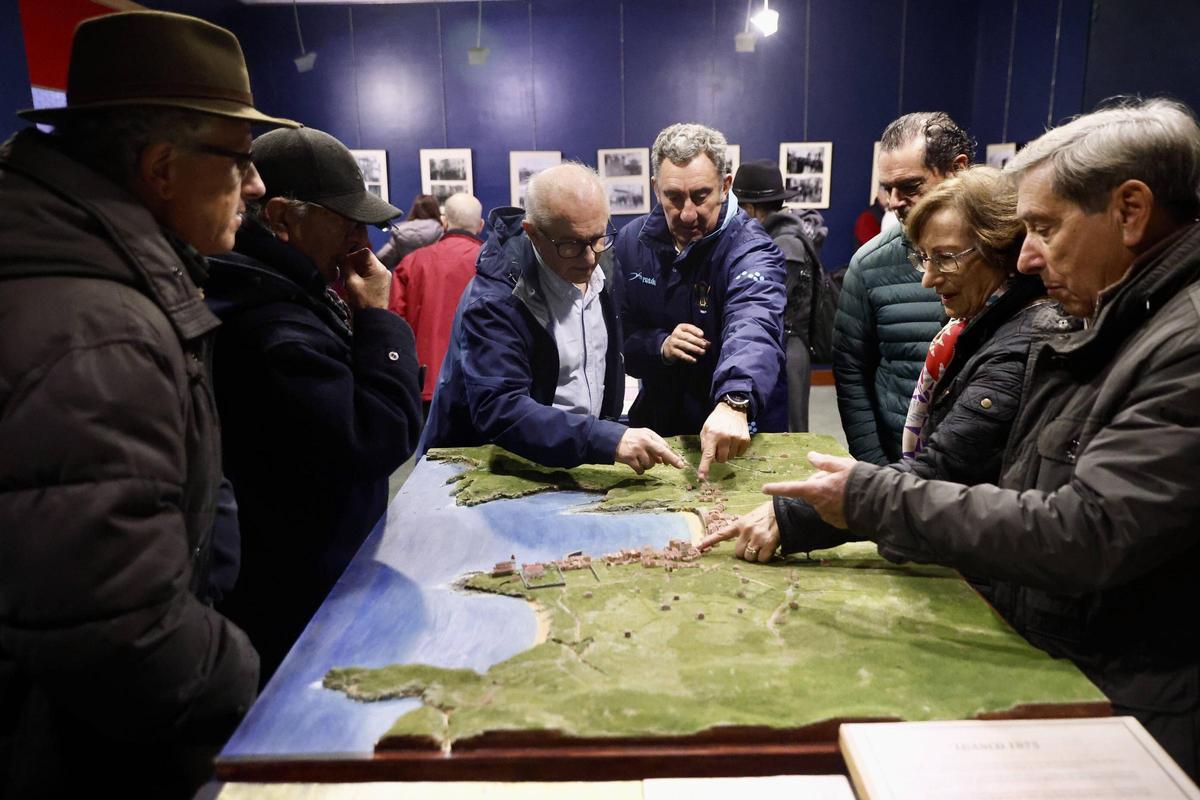 Varios luanquinos admiran una maqueta del siglo XIX de Luanco.