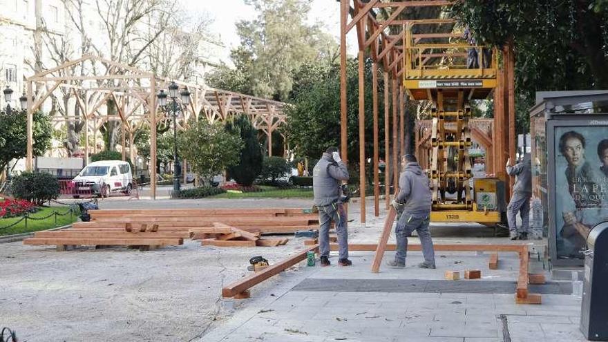 Operarios aceleran el montaje del mercadillo en la Alameda, que tendrá también un carrusel. // Alba Villar