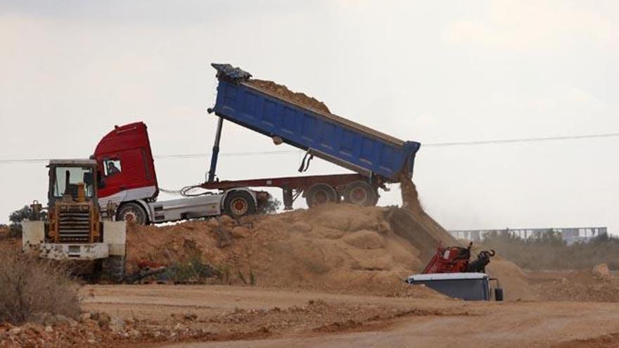 Un camión vierte la tierra sobre la cribadora para hacer una selección del material, en los terrenos del Grupo de Empresas Matutes.