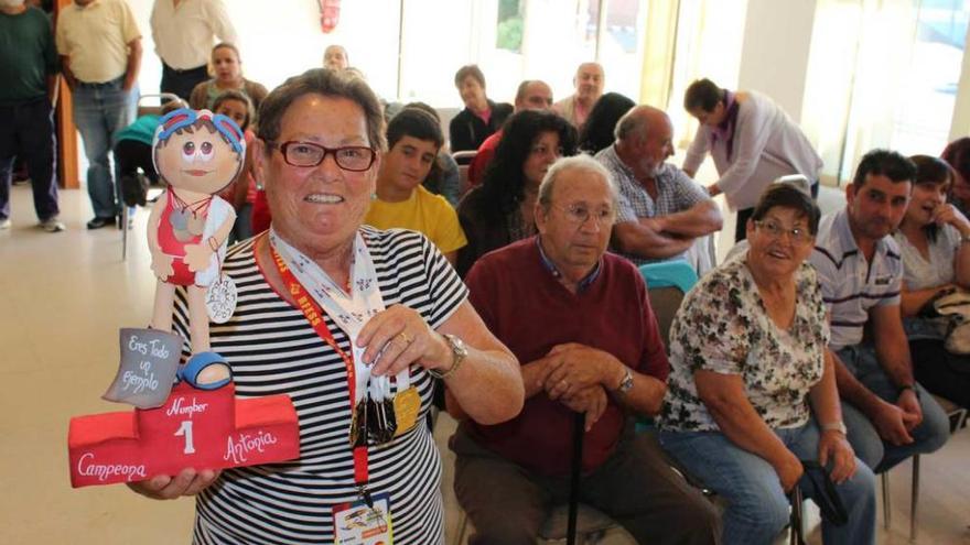 María Antonia Martínez, ayer, con un regalo, rodeada de vecinos en el salón de plenos franquino.