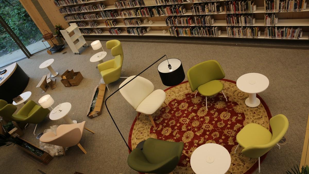 Uno de los rincones de lectura con alfombras y sillones orejeros.