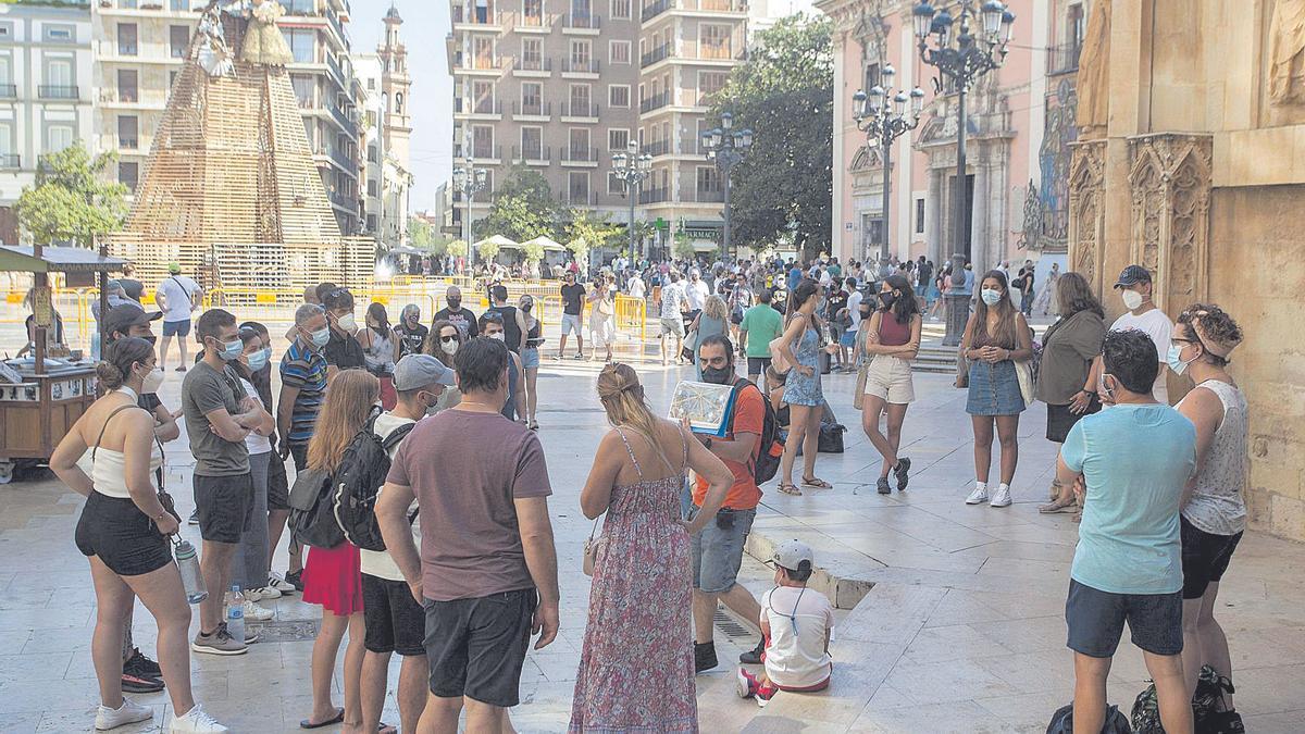 Un grupo de turistas en la plaza de la Virgen, este sábado, frente a la estructura en la que los valencianos hacen la Ofrenda de Flores.