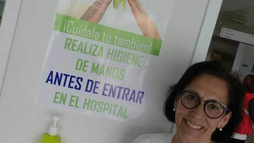 Blanca Martínez, supervisora de enfermería, ante un cartel divulgador del Día Mundial del Lavado de Manos, en uno de los vestíbulos del HUCA.