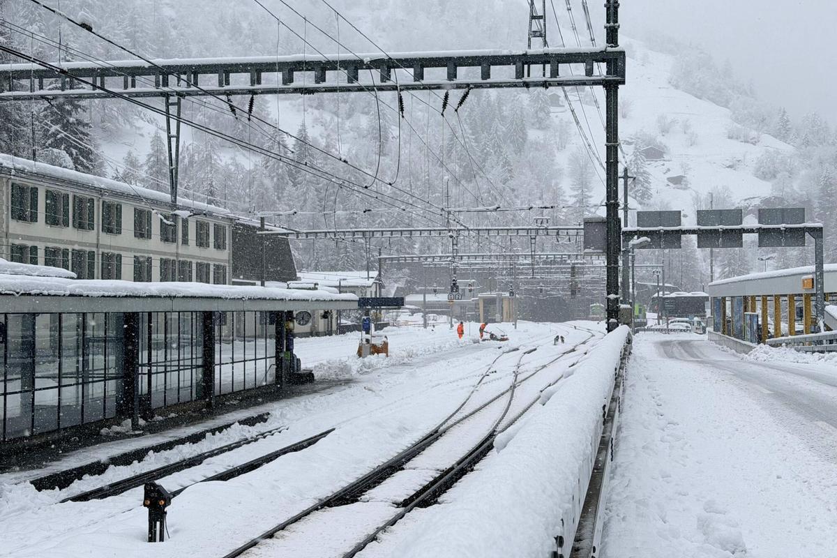 Los empleados limpian la nieve del ferrocarril después de una fuerte nevada, que causó el descarrilamiento de un tren regional, en la estación de Goppenstein, sur de Suiza, el 16 de febrero de 2026.
