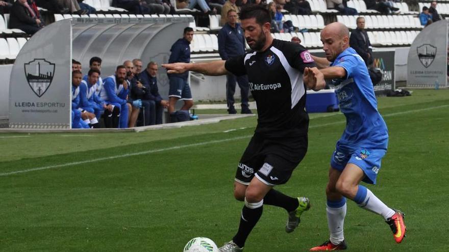 Biel Guasp resiste la presión del ex blanquiazul Casares ante el banquillo del Atlético Baleares en Lleida.