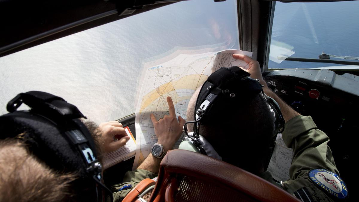 Un militar australiano observa un mapa mientras vuela sobre el océano índico en busca del avión de Malaysian Airlines MH370, el 27 de marzo de 2014.