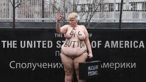 Una activista del movimiento Femen parodia a la mención de Trump sobre el tamño de su botón nuclear, ante la embajada de EEUU en Kiev (Ucrania).