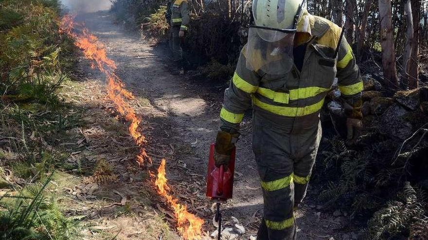 Un brigadista realiza un cortafuegos en un incendio en la parroquia de Tenorio (Cotobade) // Rafa Vázquez