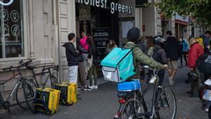 Varios ’riders’ esperan ante un restaurante de Barcelona para recoger pedidos.