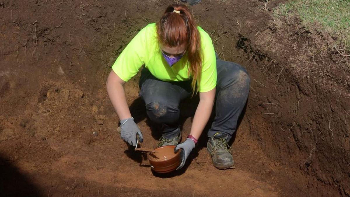 Una arqueóloga recoge muestras de sustrato de la tierra, ayer en el cementerio de Rubiáns.