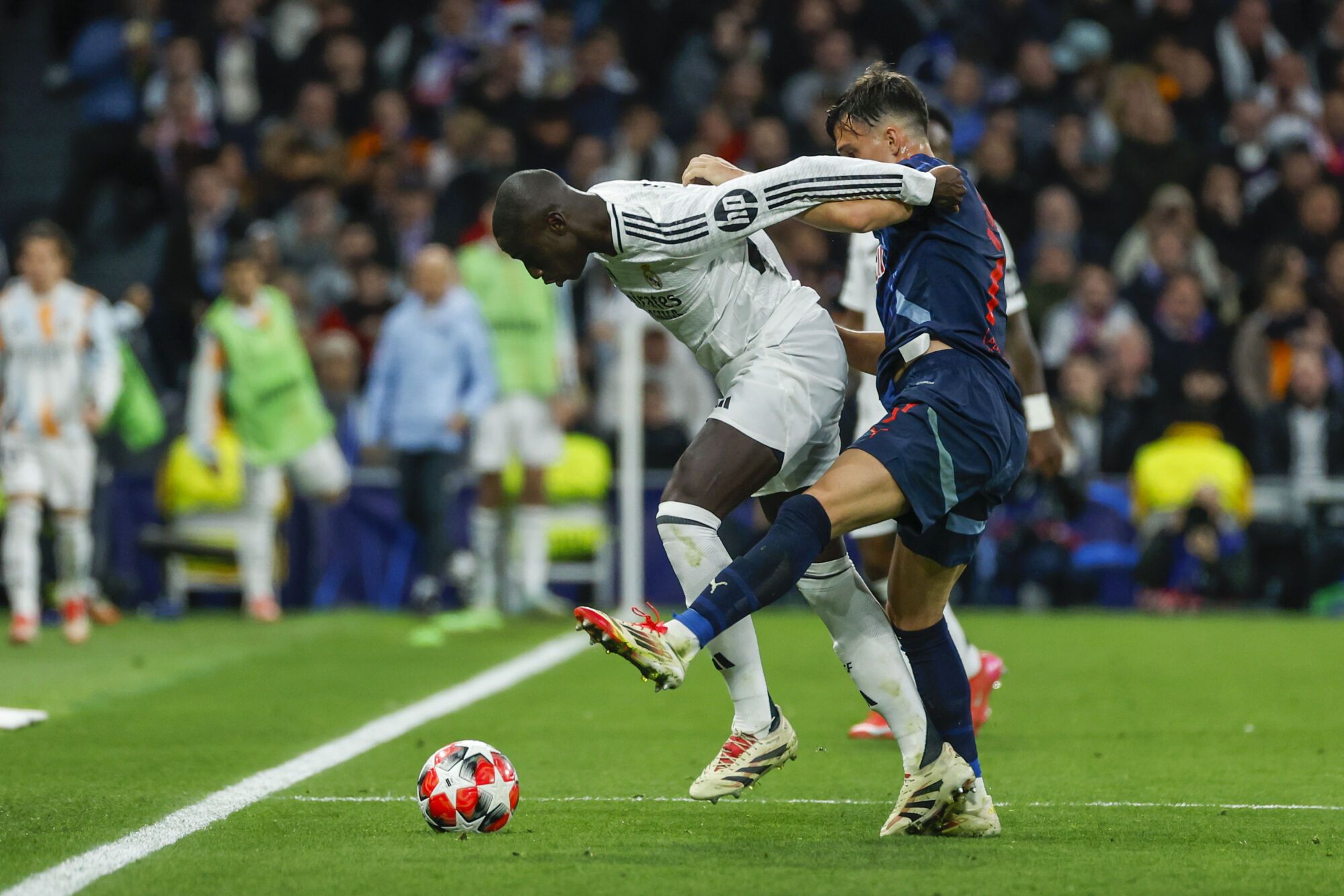 MADRID, 22/01/2025.- El defensa francés del Real Madrid Ferland Mendy (i) pelea un balón con el centrocampista argentino Nicolás Capaldo, del Salzburgo, durante el partido de la Liga de Campeones de fútbol que Real Madrid y FC Salzburgo disputan este miércoles en el estadio Santiago Bernabéu. EFE/JuanJo Martín