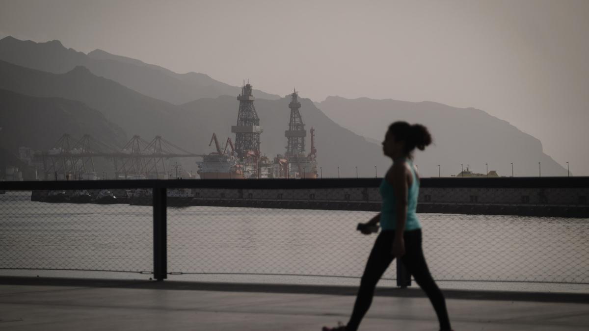 Una mujer pasea en Santa Cruz bajo una intensa calima.