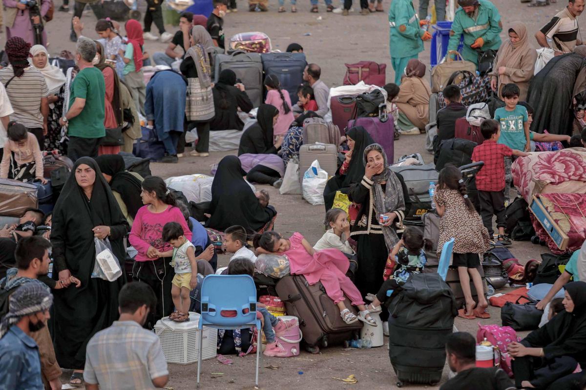 Refugiados afganos, repatriados desde Irán, esperan en el paso fronterizo de Islam Qala, situado en la provincia afgana de Herat.