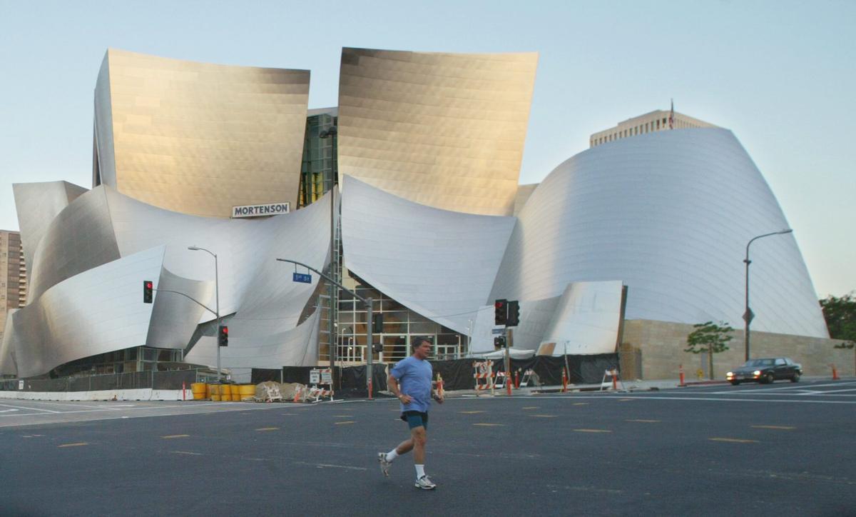 A jogger makes his way across the street in front of the Walt Disney Concert Hall in Los Angeles in this June 25, 2003 photo. With a dramatic, curved steel exterior that looks more like sculpture than architecture, the hall is being counted on to provide much more than a new home for the Los Angeles Philharmonic. When the $274-million, Frank Gehry-designed building opens this fall, local government officials and business leaders are banking on it becoming an immediate icon in the downtown area. (AP Photo/Damian Dovarganes)