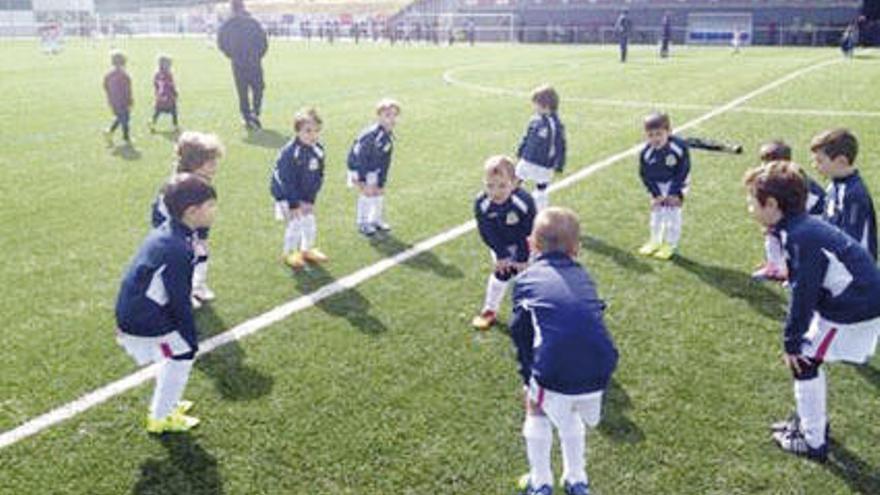 Miembros de la Escola Estrada Fútbol Base realizan ejercicios de calentamiento antes de un partido.