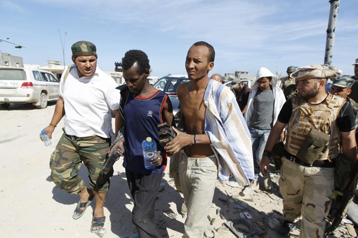 Combatents rebels prenen com a presoner un combatent lleial a Gaddafi.