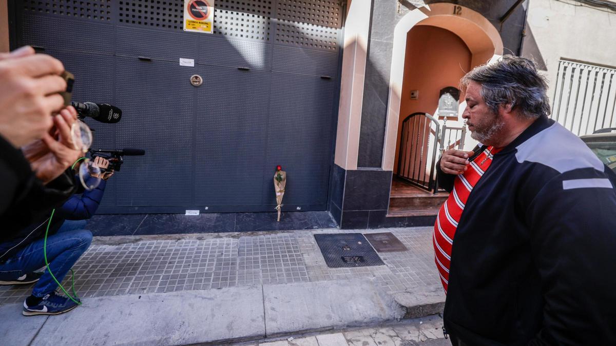 Un hombre deposita una rosa frente a la casa de El Prat donde un hombre ha matado a su mujer y sus hijos y se ha suicidado