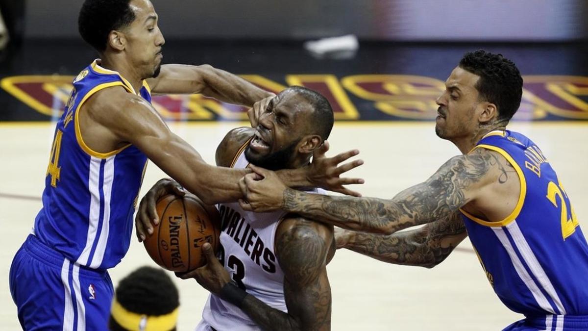 Lebron James entra a canasta ante el duro marcaje de Shaun Livingston y Matt Barnes.